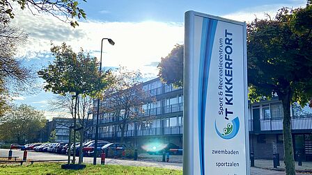 Een grote zuil buiten bij de parkeerplaats van het zwembad. Daarop staat de naam van 't Kikkerfort en het logo